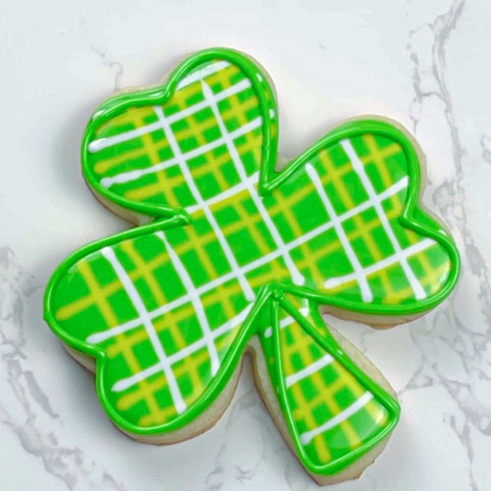 Plaid shamrock cookie on a marble countertop