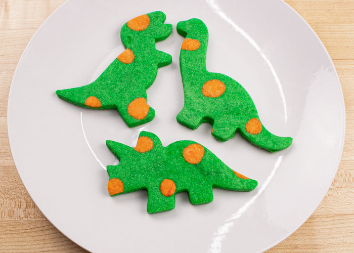 Image of green dinosaur cookies with orange polka dots
