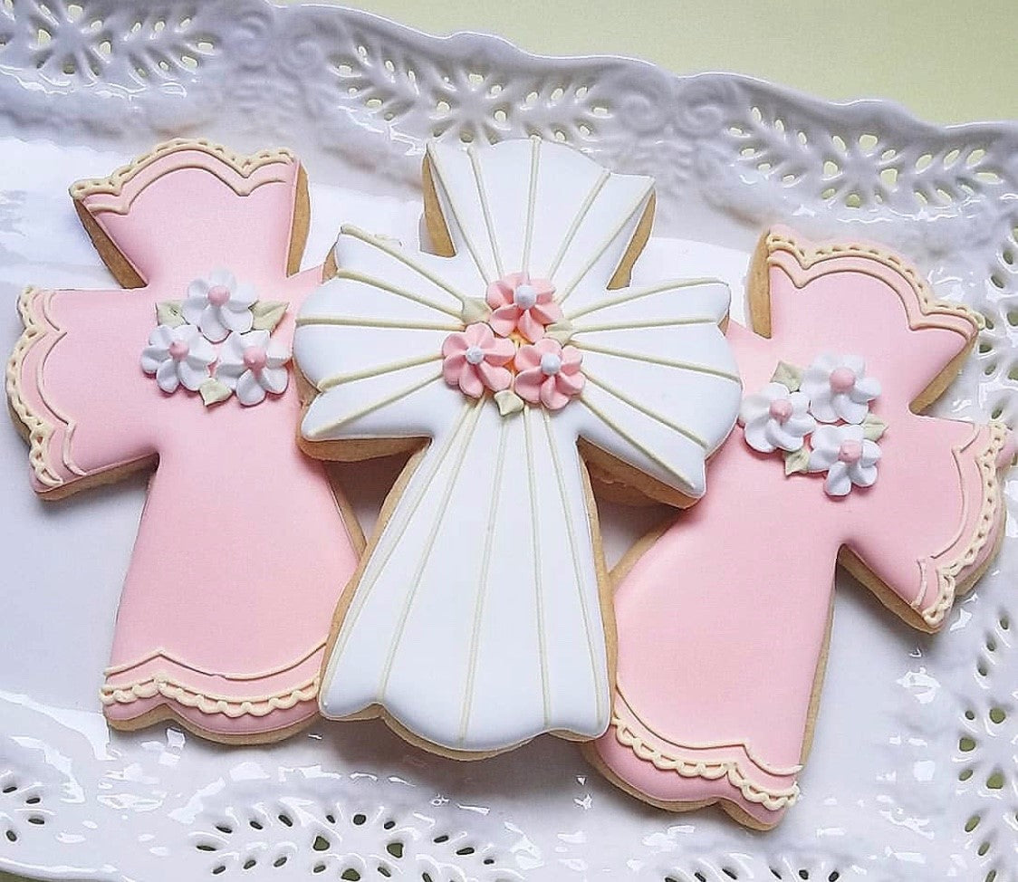 three beautiful cross cookies decorated with icing on a plate