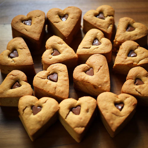 blondies in the shape of hearts on a wood table 