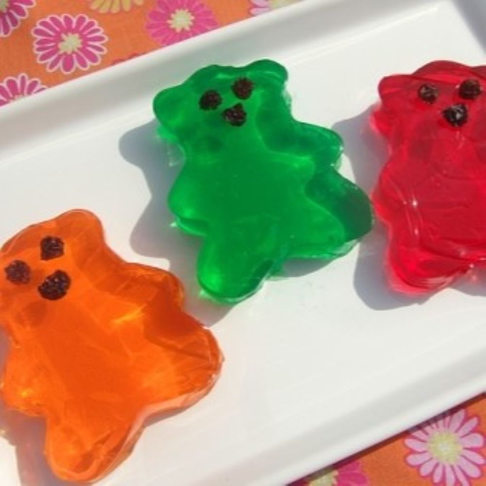 jiggly fruit gel shaped as teddy bears in multiple colors on a white plate 