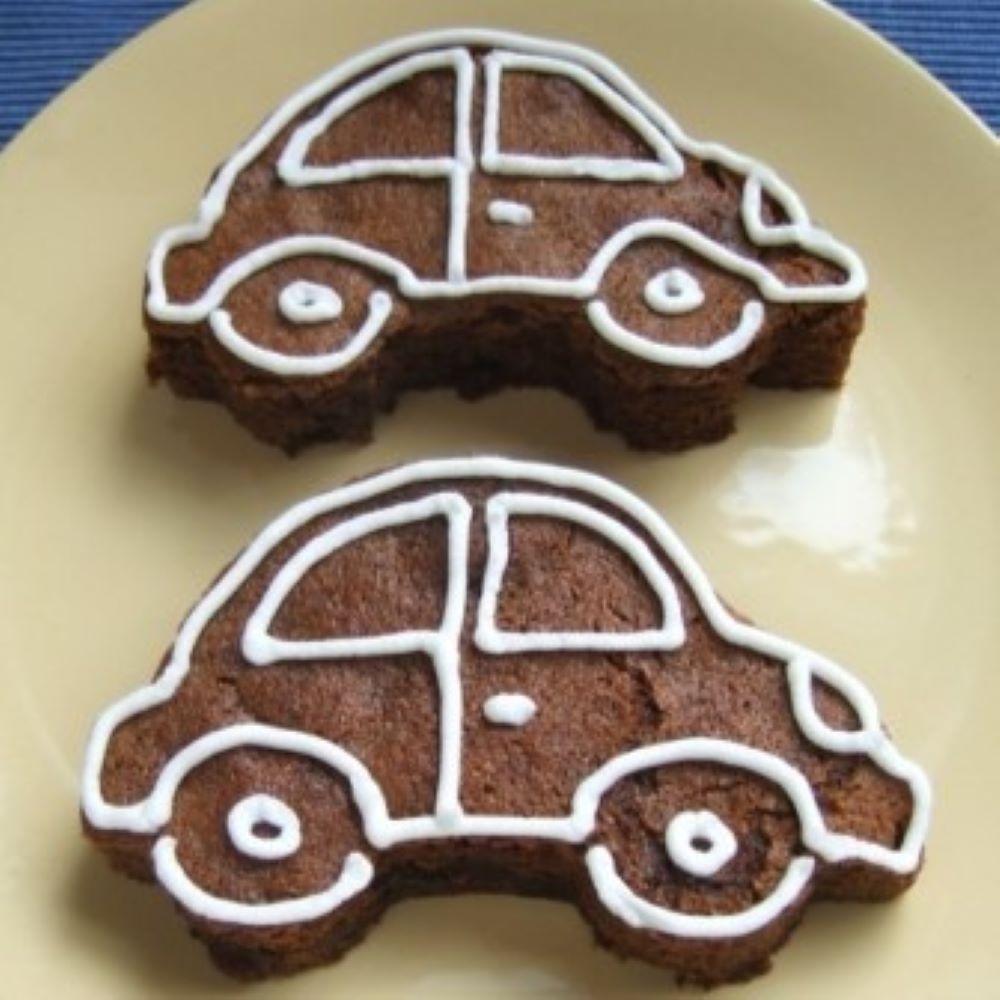 car shaped molasses raisin bars with white detail royal icing on a light yellow plate