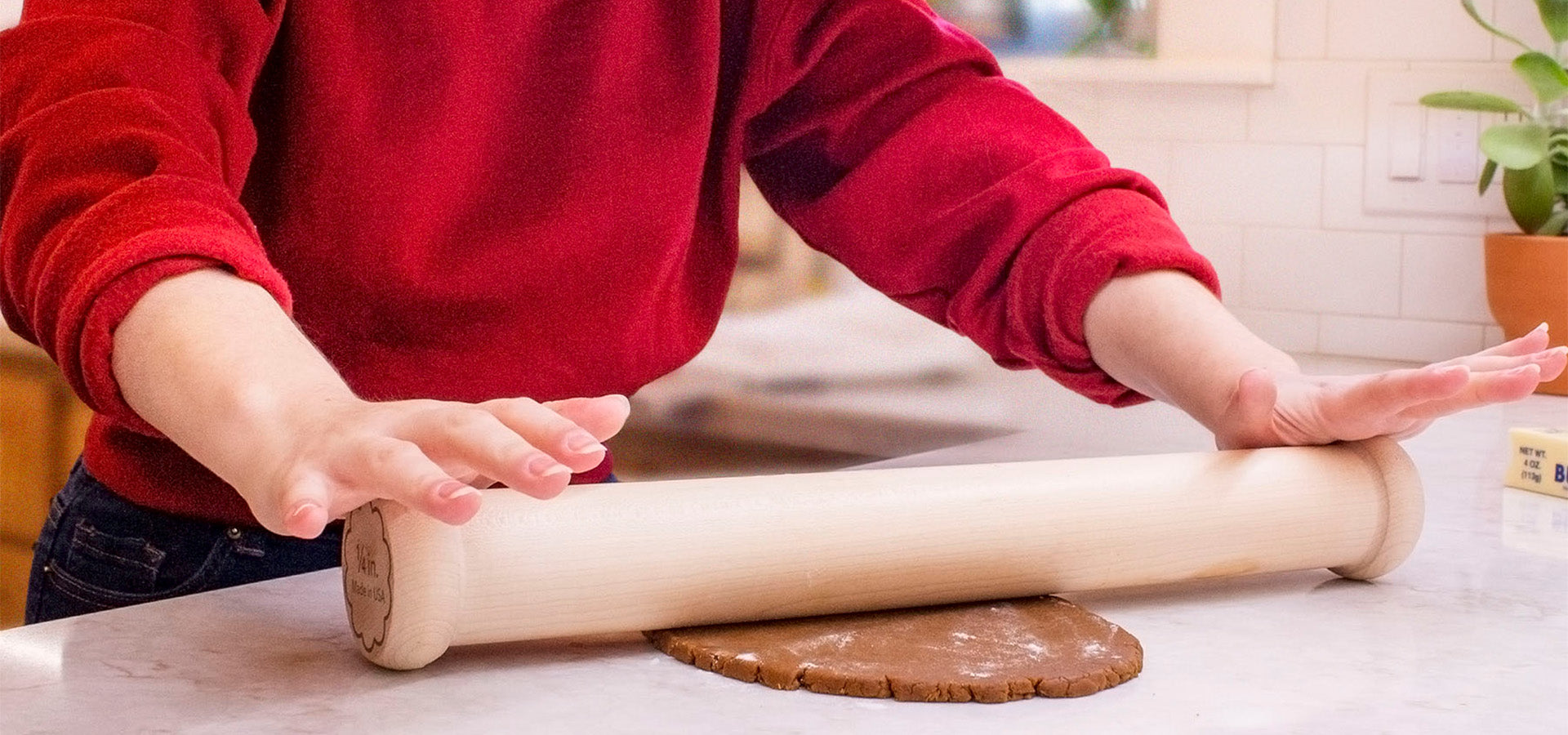 Woman using large Ann Clark rolling pin to roll out cookie dough