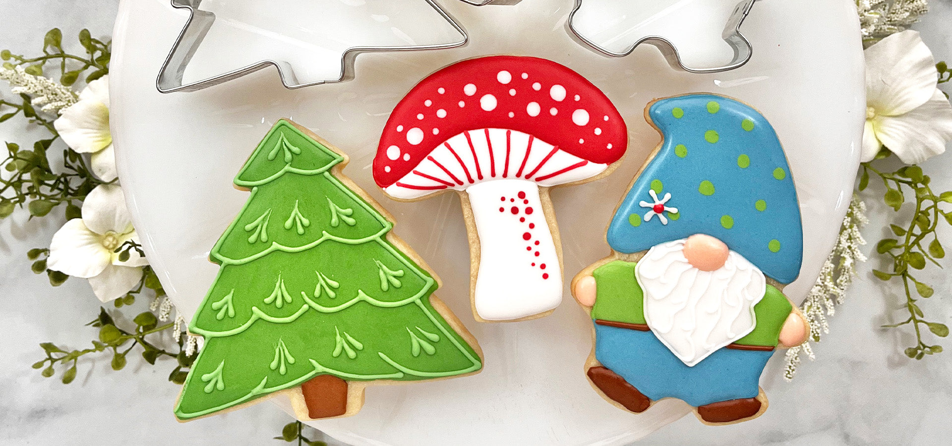 Tree, mushroom, and gnome cookie on a white plate