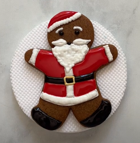 Image of a gingerbread man cookie decorated to look like Santa Claus.