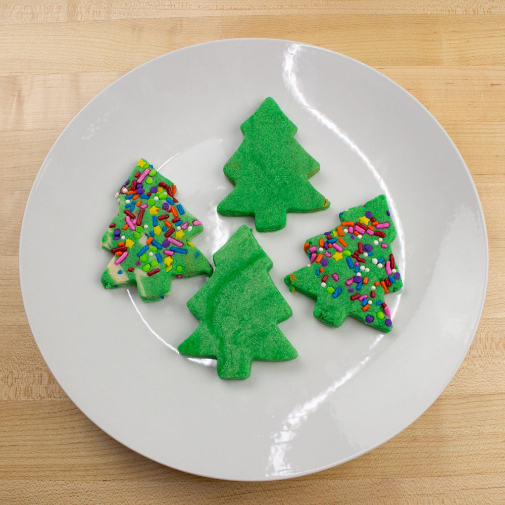 Image of green evergreen tree cookies on a white plate.