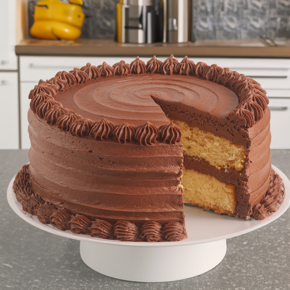 Image of a yellow cake with chocolate frosting on a cake stand.