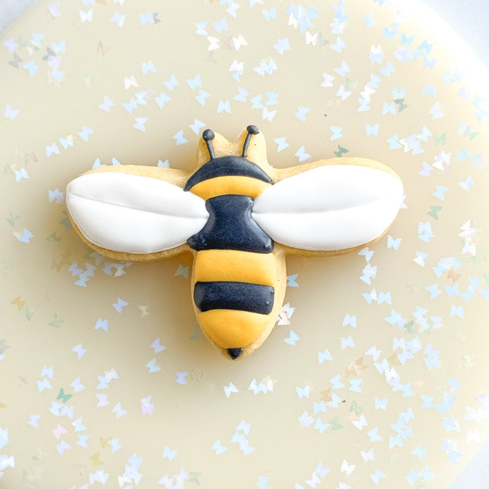 Image of a bee shaped cookie decorated with royal icing.
