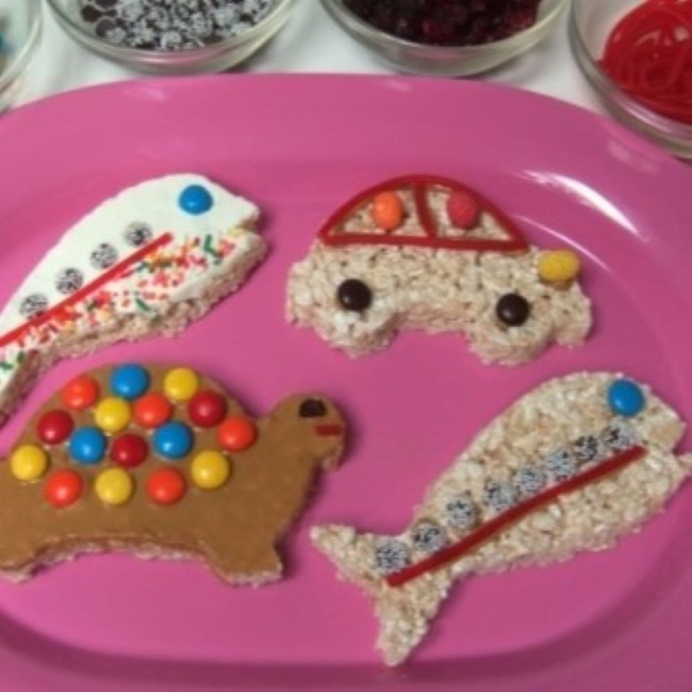 crispy rice cut outs of a fish, car, and turtle on a bright pink plate