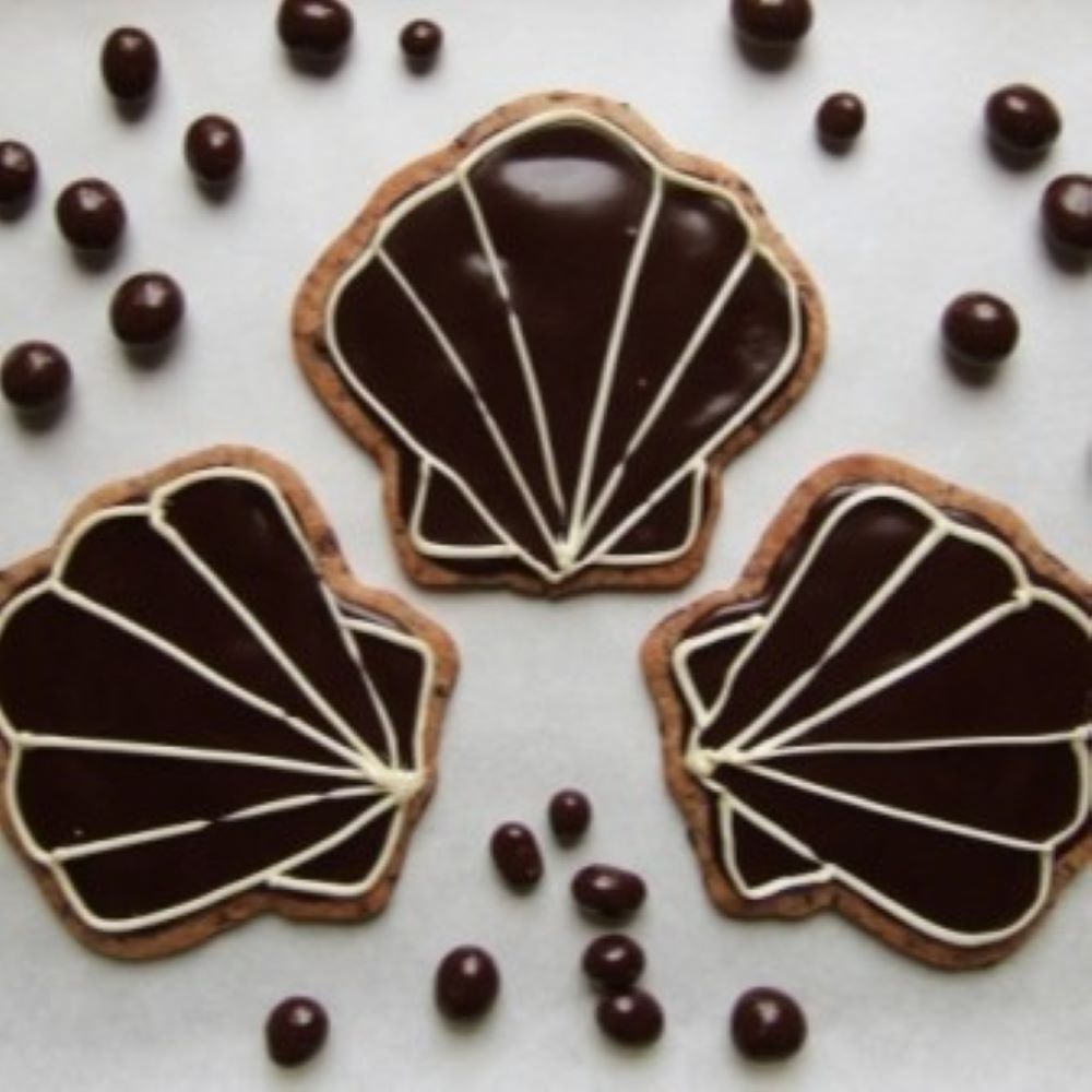 seashell shaped cookies with chocolate icing surrounded by cookie dough balls