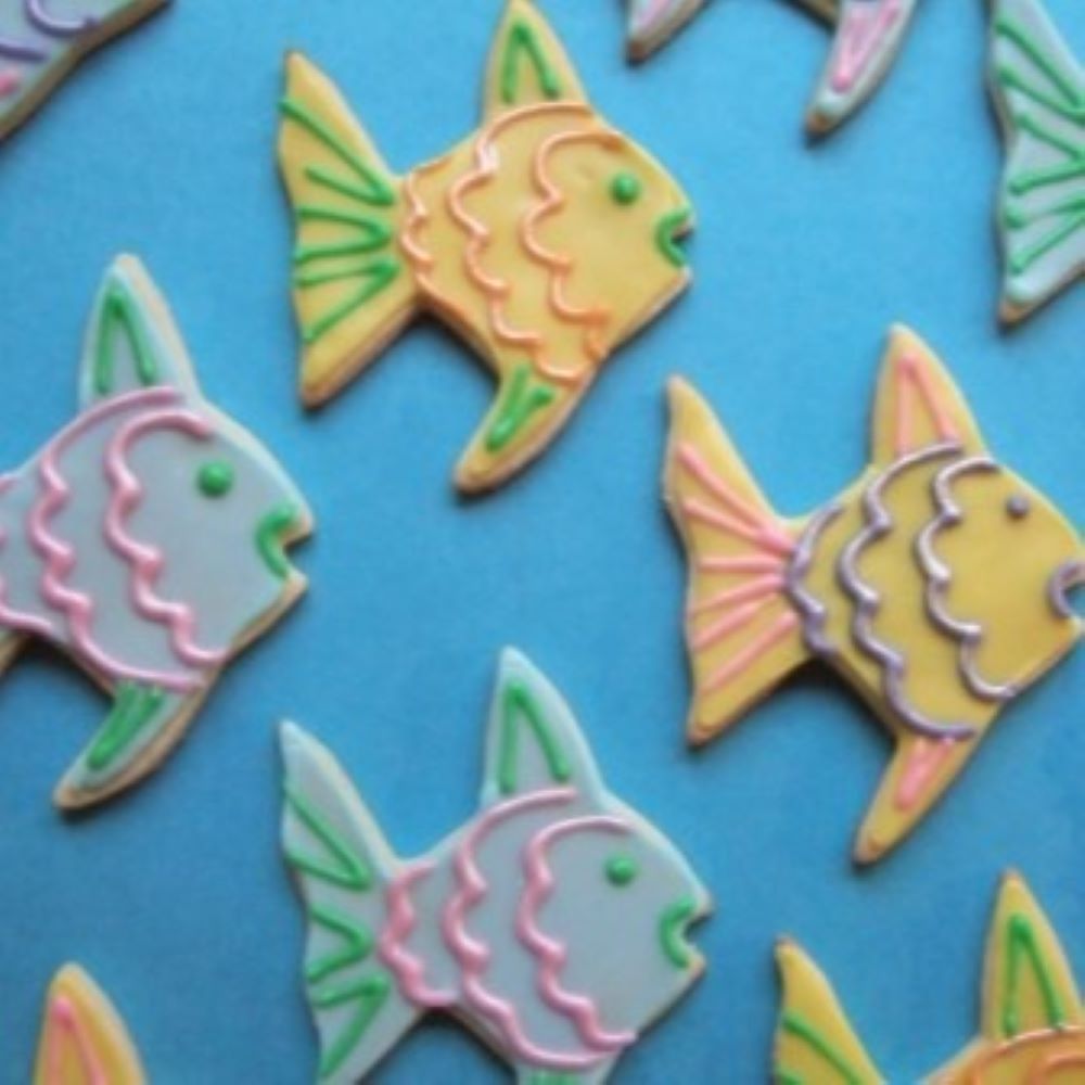 colorful angel fish shaped cookies on a blue background