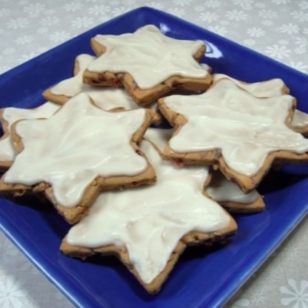 a bunch of glazed star shaped cookies on a blue plate