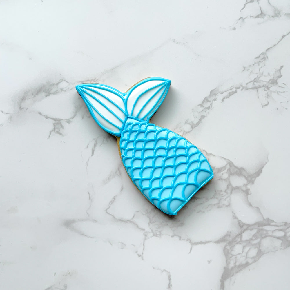 Blue mermaid tail cookie on a marble countertop