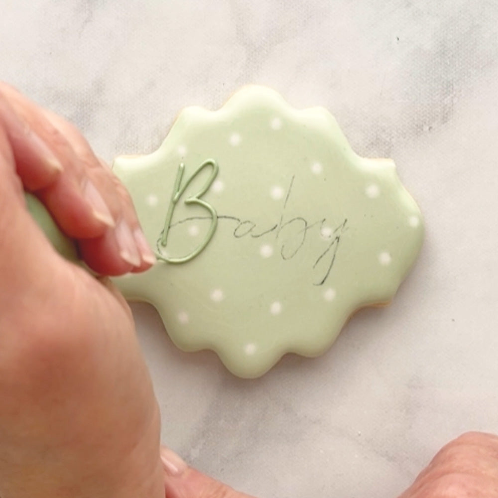 Green cookie with "Baby" written on it