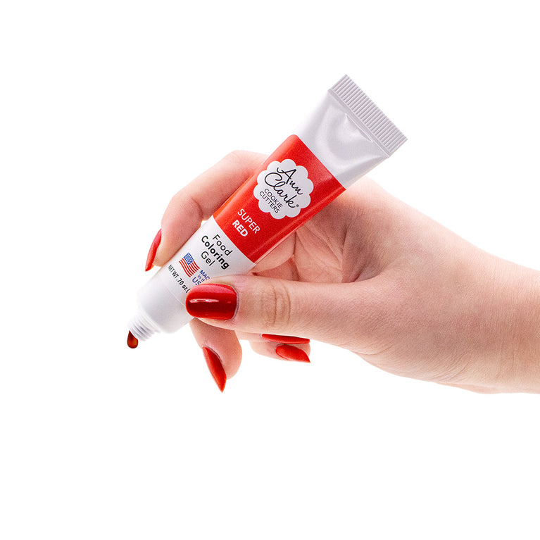 Hand holding a tube of Ann Clark Super Red Food Coloring Gel